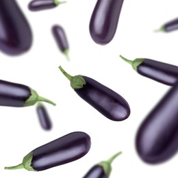 Fresh whole eggplants falling on white background