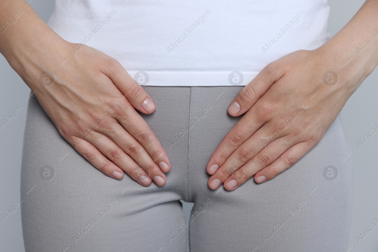Photo of Woman suffering from herpes genital on grey background, closeup