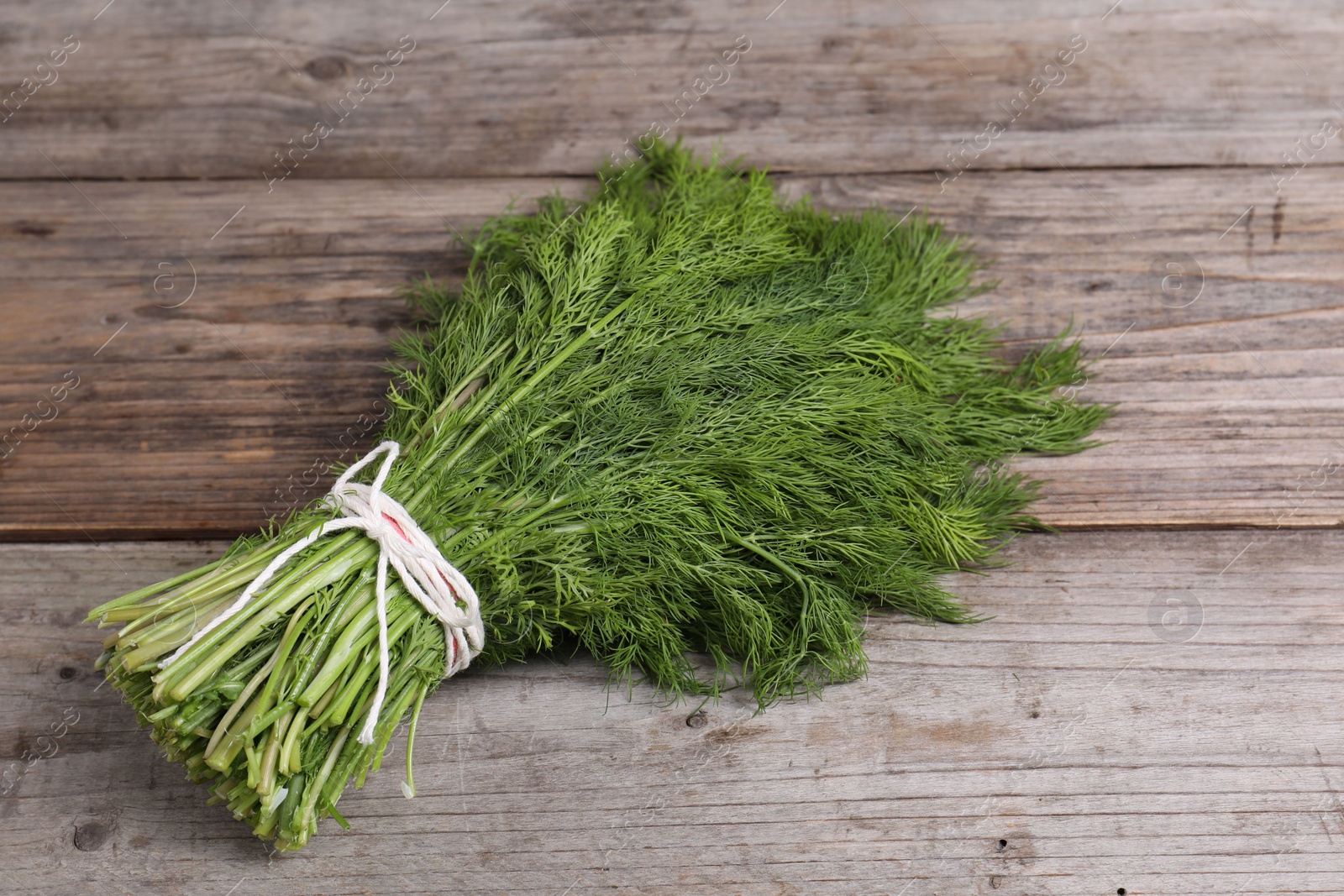 Photo of Bunch of fresh green dill on wooden table