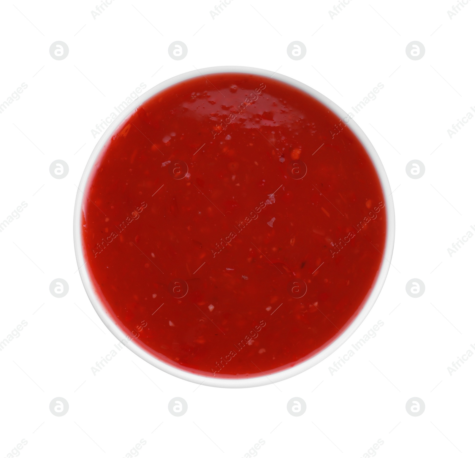 Photo of Spicy chili sauce in bowl isolated on white, top view