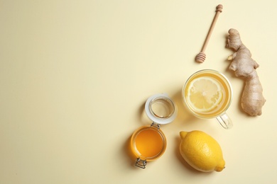 Flat lay composition with cup of lemon tea, ginger and honey on color background. Space for text