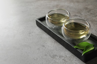 Photo of Glass cups of freshly brewed oolong tea on table. Space for text