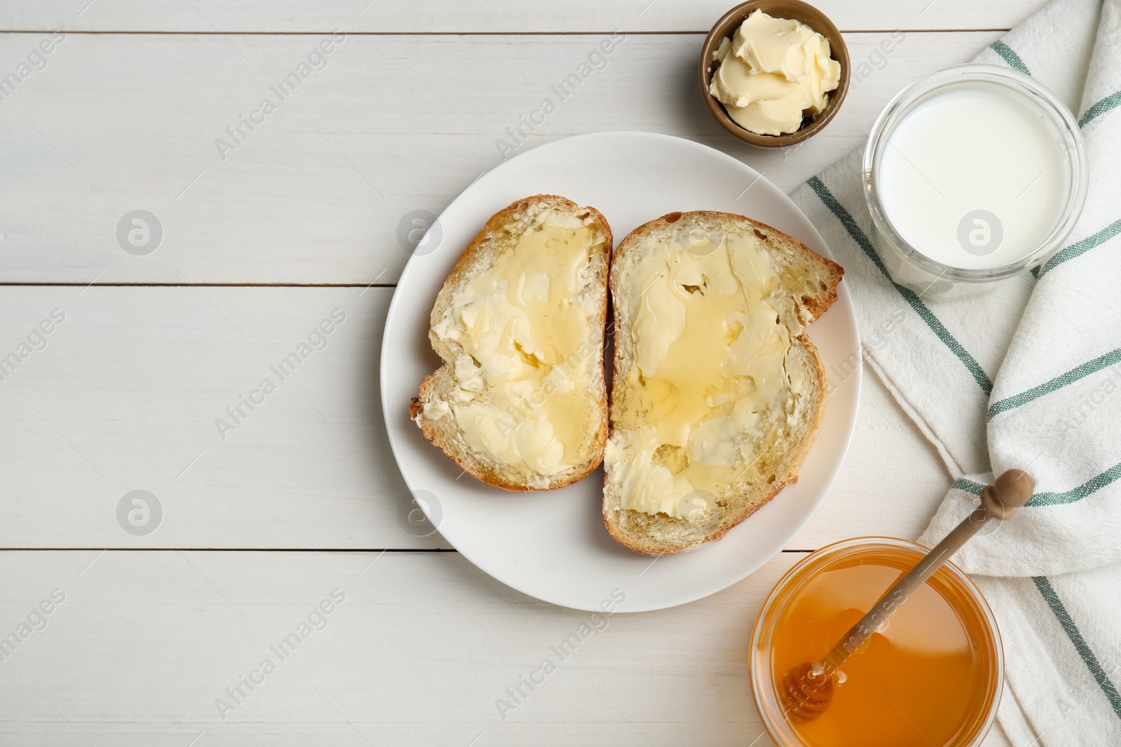 Photo of Flat lay composition of sandwiches with butter, honey and milk on white wooden table, space for text