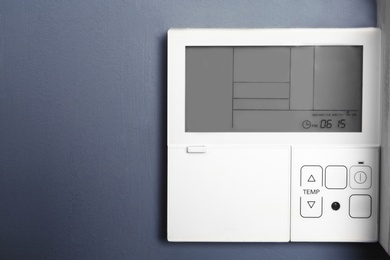 Photo of Modern thermostat on grey wall with space for text. Heating system