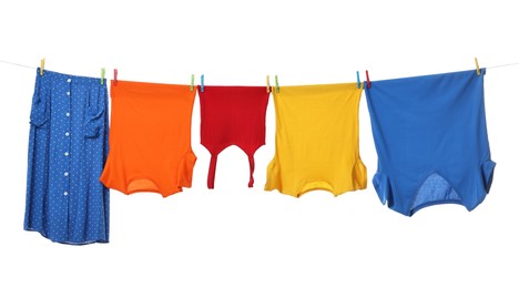 Different clothes drying on laundry line against white background