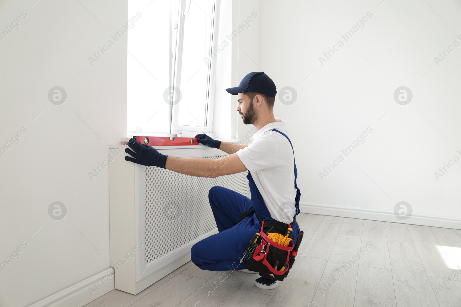 Photo of Handyman working with building level indoors. Professional construction tools