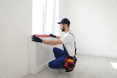 Handyman working with building level indoors. Professional construction tools