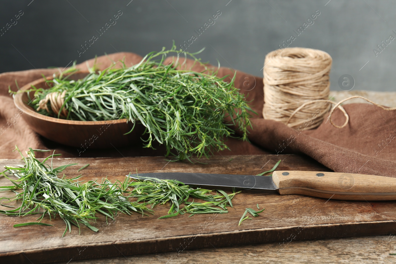 Photo of Fresh whole and cut tarragon sprigs on table