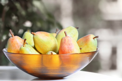Photo of Fresh ripe pears on light table indoors