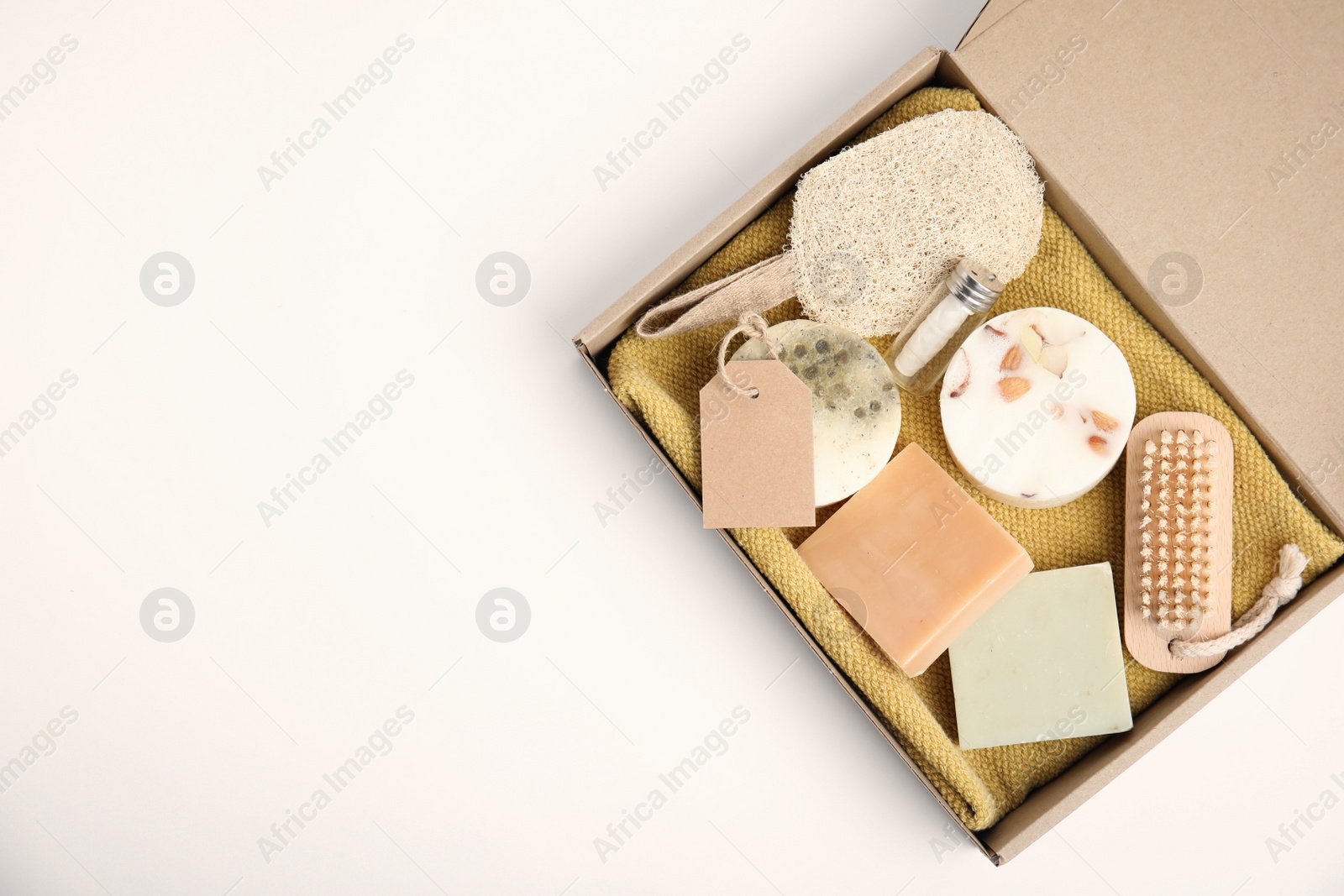 Photo of Cardboard box with eco friendly personal care products on white background, top view. Space for text