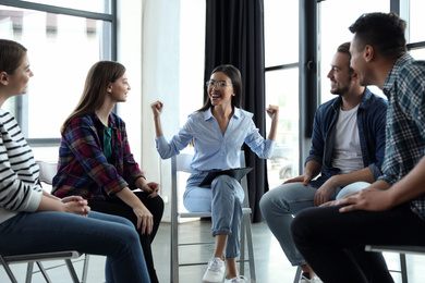 Photo of Psychotherapist working with patients in group therapy session indoors