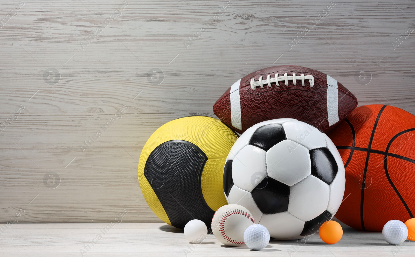 Photo of Many different sport balls on white wooden background, space for text