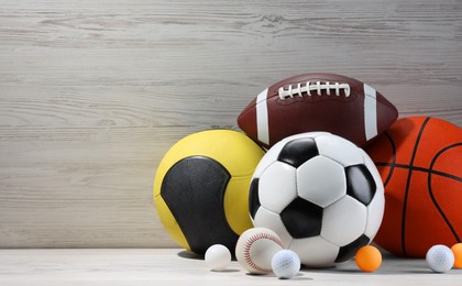 Photo of Many different sport balls on white wooden background, space for text