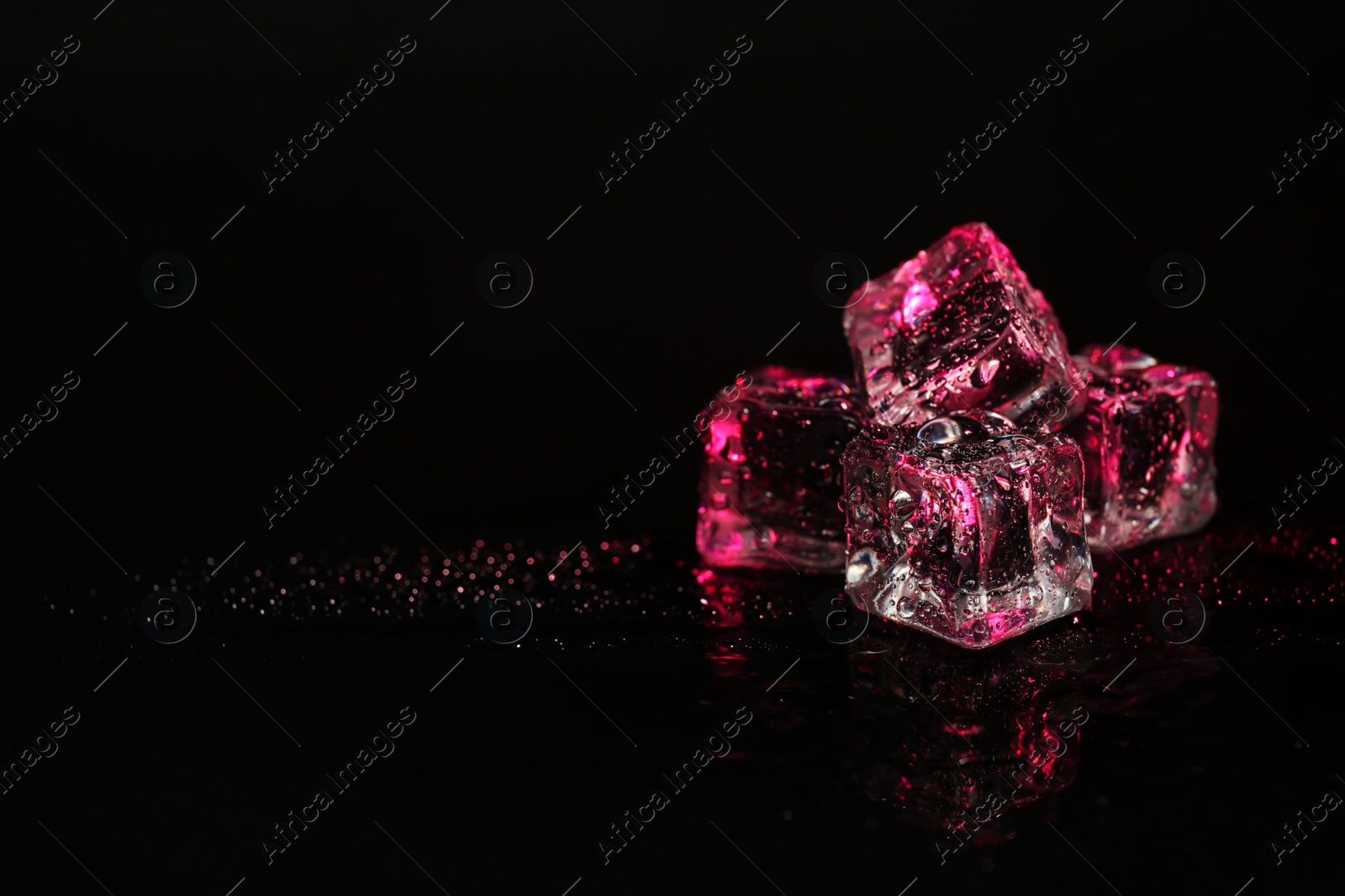 Photo of Pile of crystal clear ice cubes on black background. Space for text