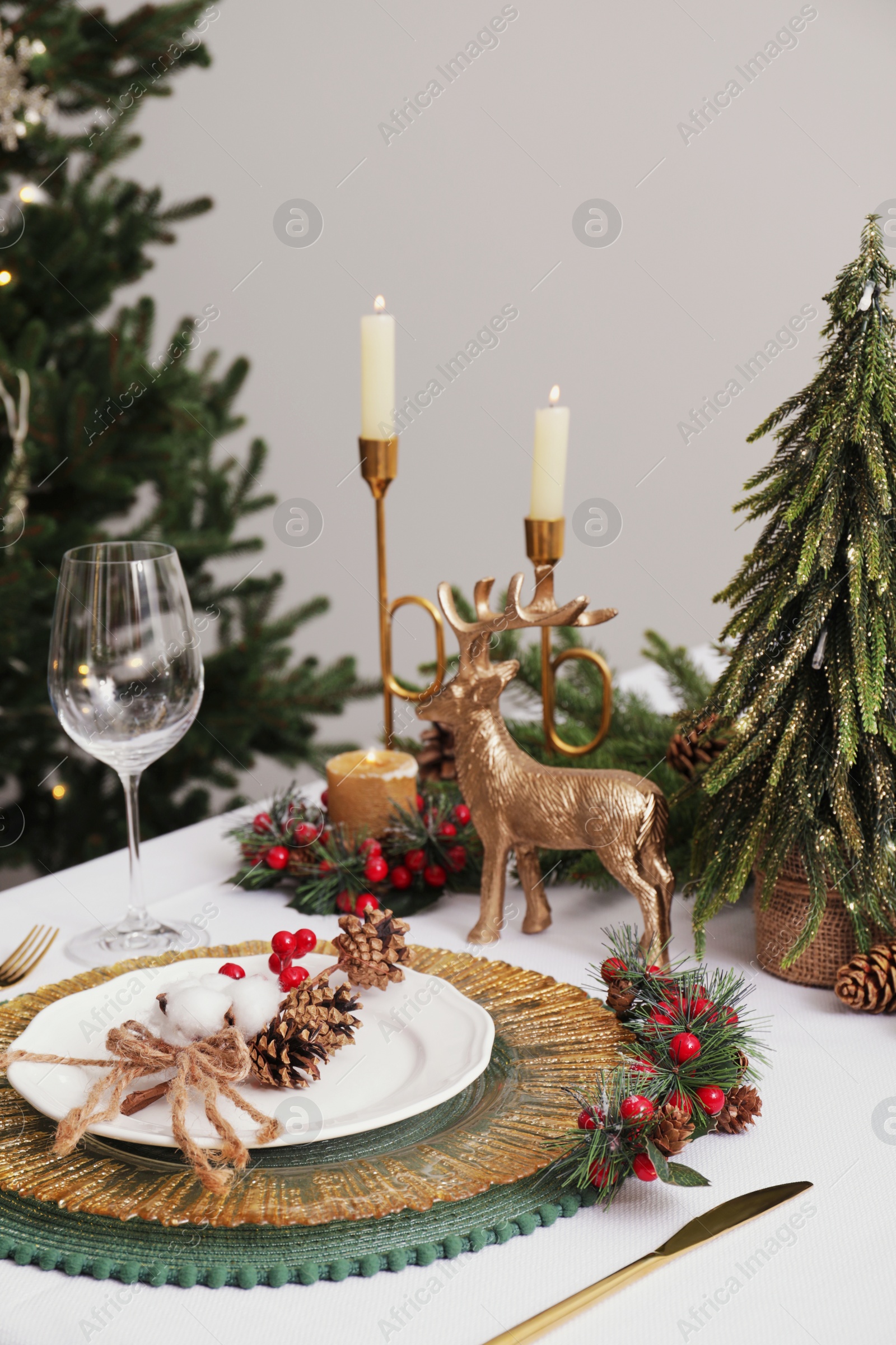 Photo of Luxury festive place setting with beautiful decor for Christmas dinner on white table indoors