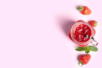 Tasty strawberry smoothie in mason jar on pink background, flat lay. Space for text