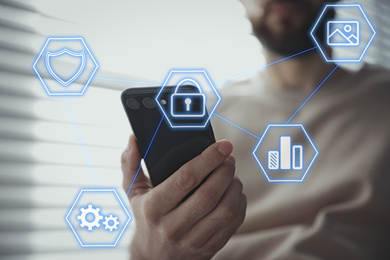 Information security. Young man using smartphone indoors, closeup