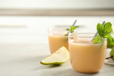 Tasty pear juice with mint on light grey table, closeup