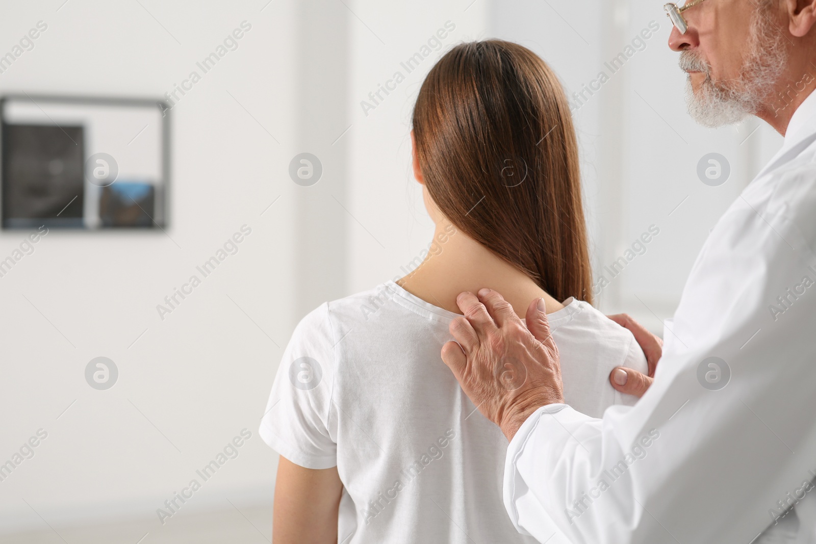 Photo of Professional orthopedist examining patient's neck in clinic, closeup