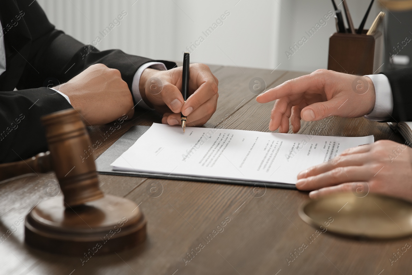 Photo of Law and justice. Lawyers working with documents at wooden table in office, closeup