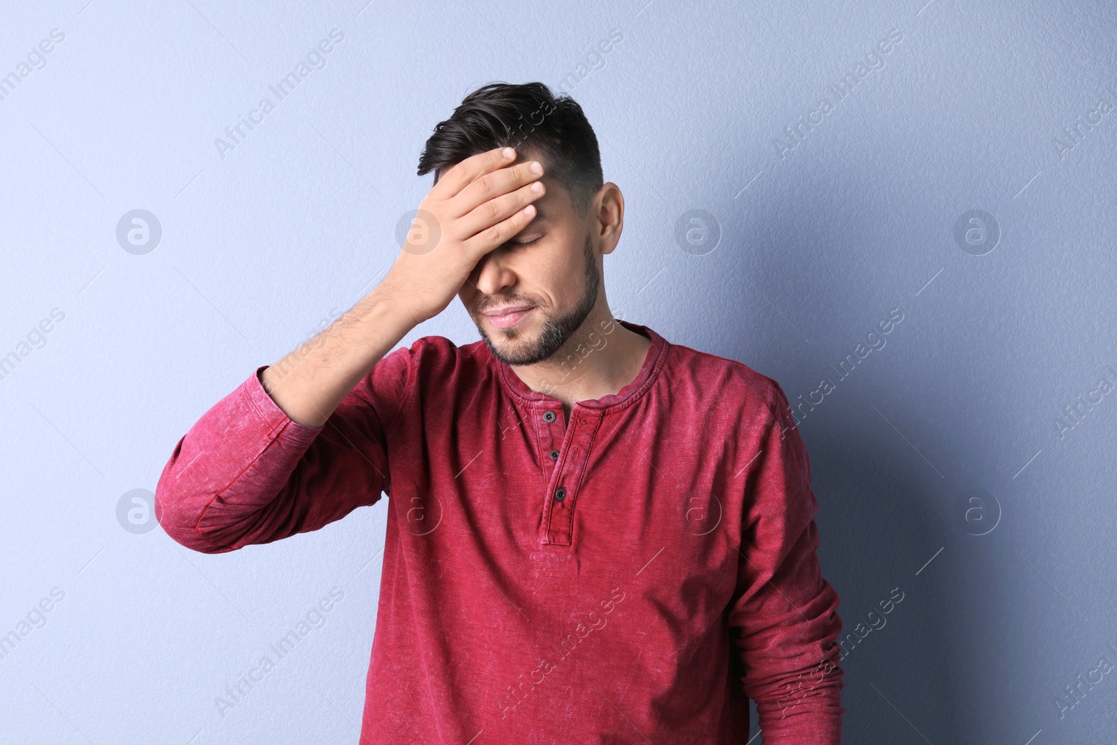 Photo of Man suffering from headache on color background