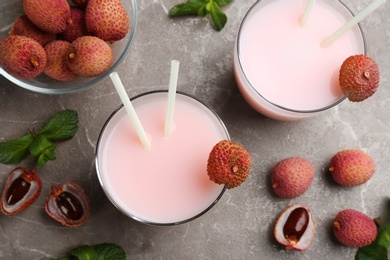 Photo of Flat lay composition with lychee cocktail on grey table, closeup