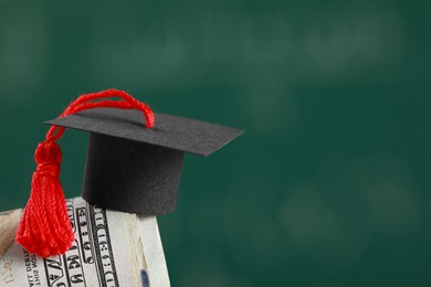 Photo of Scholarship concept. Graduation cap and dollar banknotes against blurred background, closeup with space for text