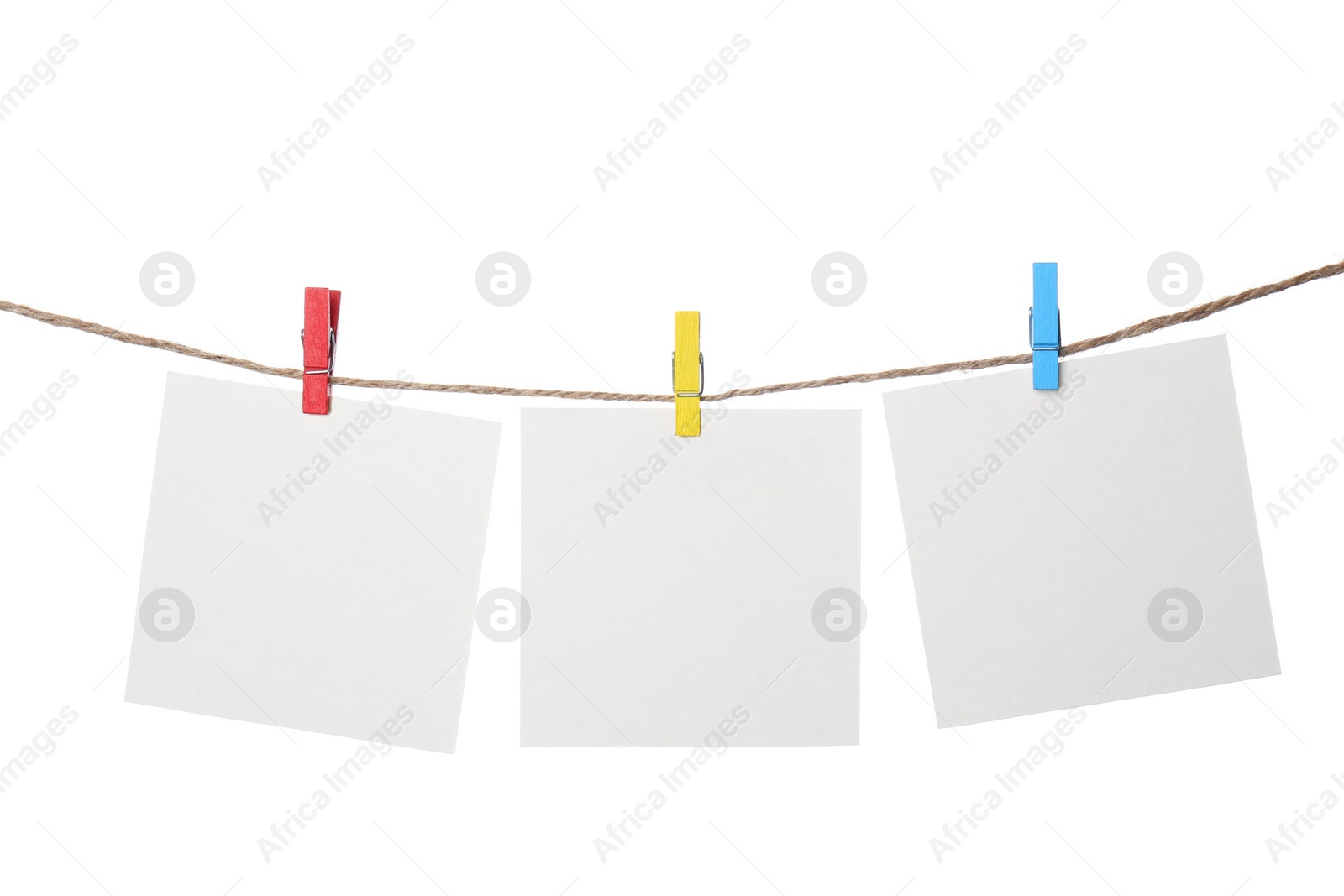 Photo of Clothespins with empty notepapers on string against white background. Space for text