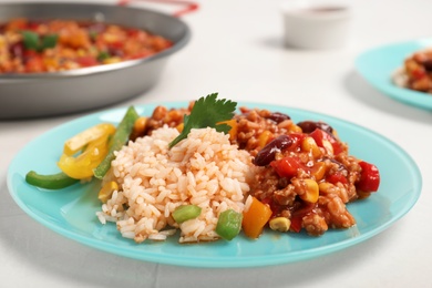 Photo of Chili con carne served with rice on table