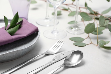 Photo of Cutlery, plate and napkin on light background, closeup. Festive table setting