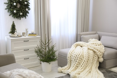 Photo of Stylish living room interior with little fir trees and Christmas decorations