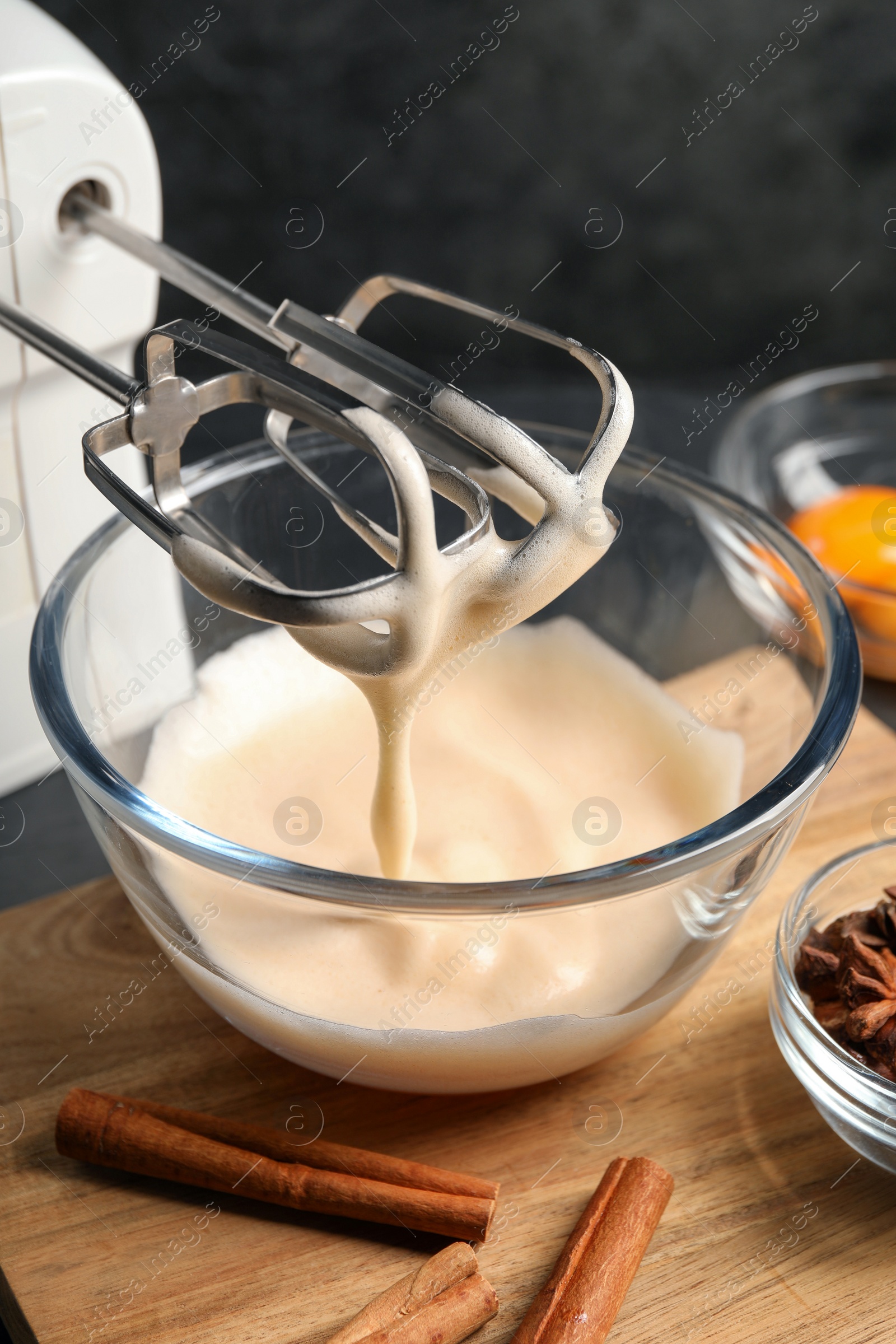 Photo of Different ingredients and mixer on black table. Cooking delicious eggnog