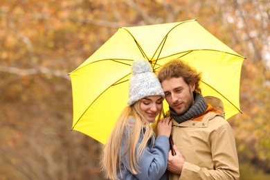 Photo of Romantic couple with umbrella in park on autumn day