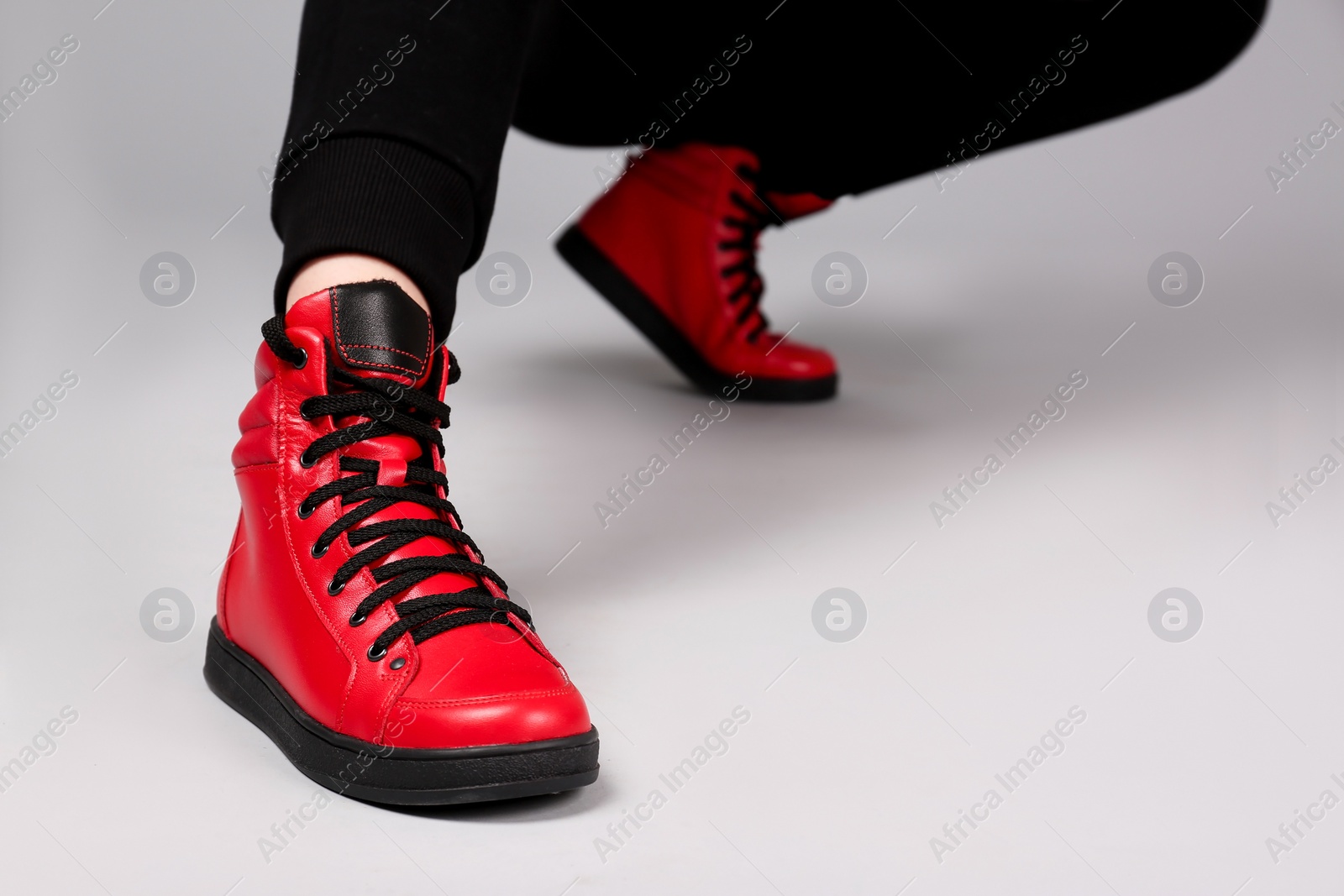 Photo of Woman in stylish sport shoes on light background