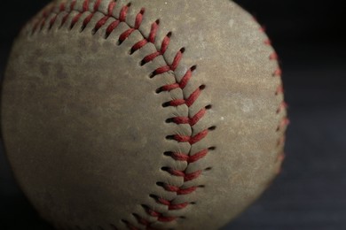Image of Worn baseball ball on black background, closeup
