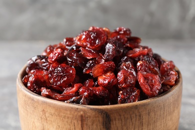 Photo of Bowl with sweet cranberries on table, closeup. Dried fruit as healthy snack