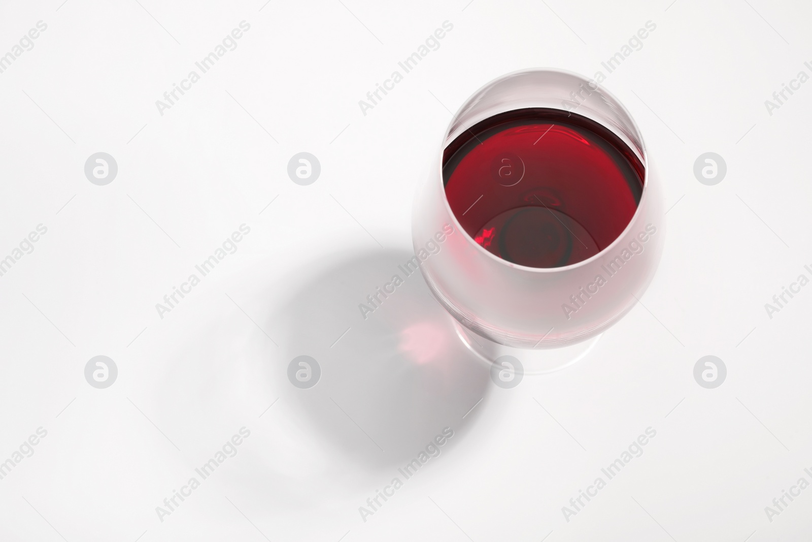 Photo of Tasty red wine in glass isolated on white, above view