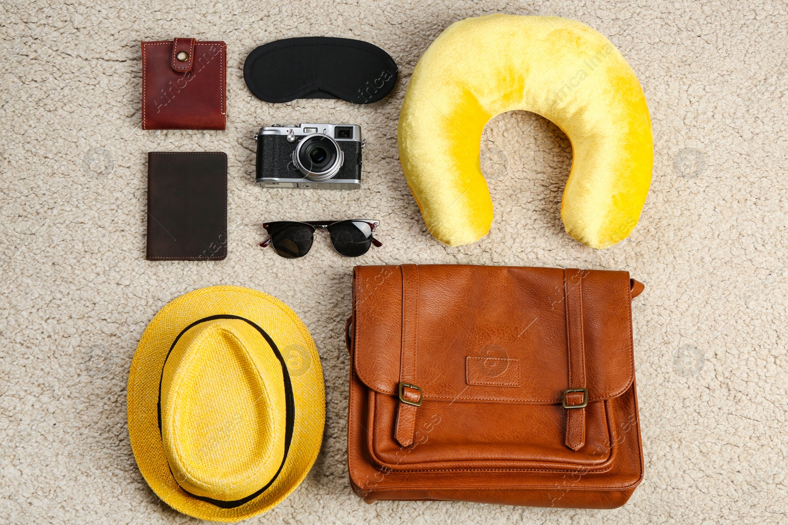 Photo of Flat lay composition with travel pillow and tourist stuff on soft carpet