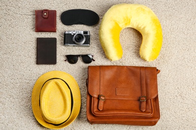 Photo of Flat lay composition with travel pillow and tourist stuff on soft carpet