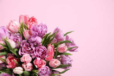 Beautiful bouquet of colorful tulip flowers on pink background. Space for text