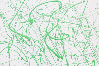 Photo of Green paint splashes on white canvas as background. Art and creativity