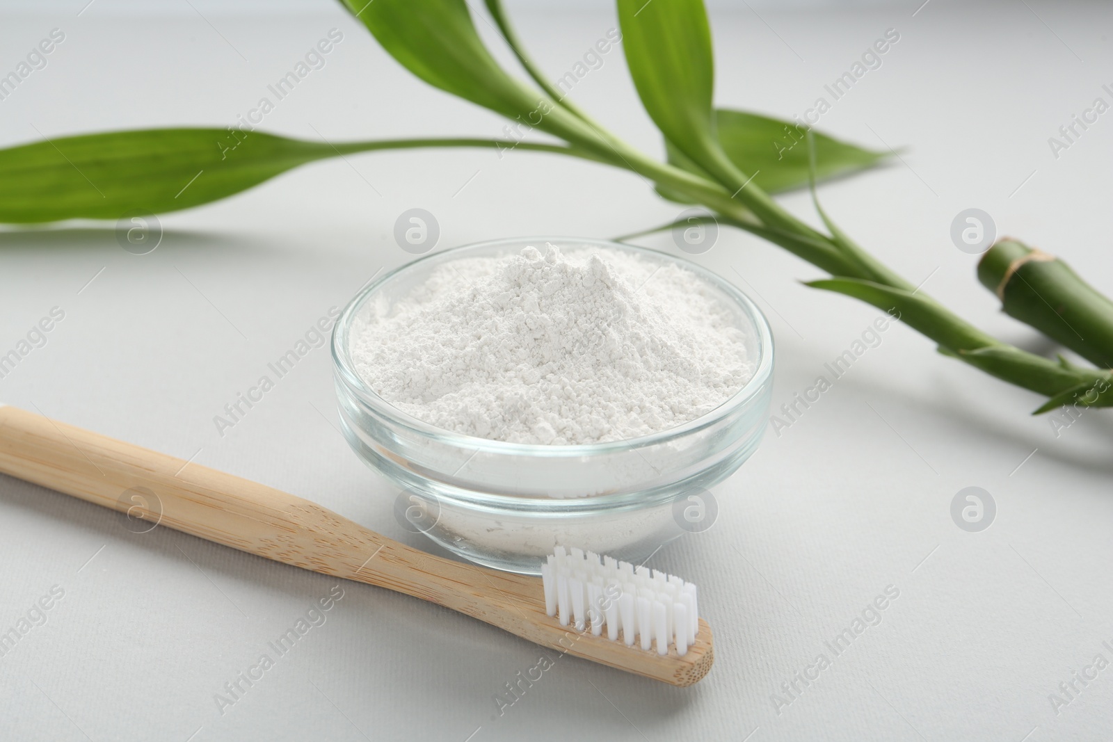 Photo of Tooth powder, brush and bamboo stem on white background, closeup