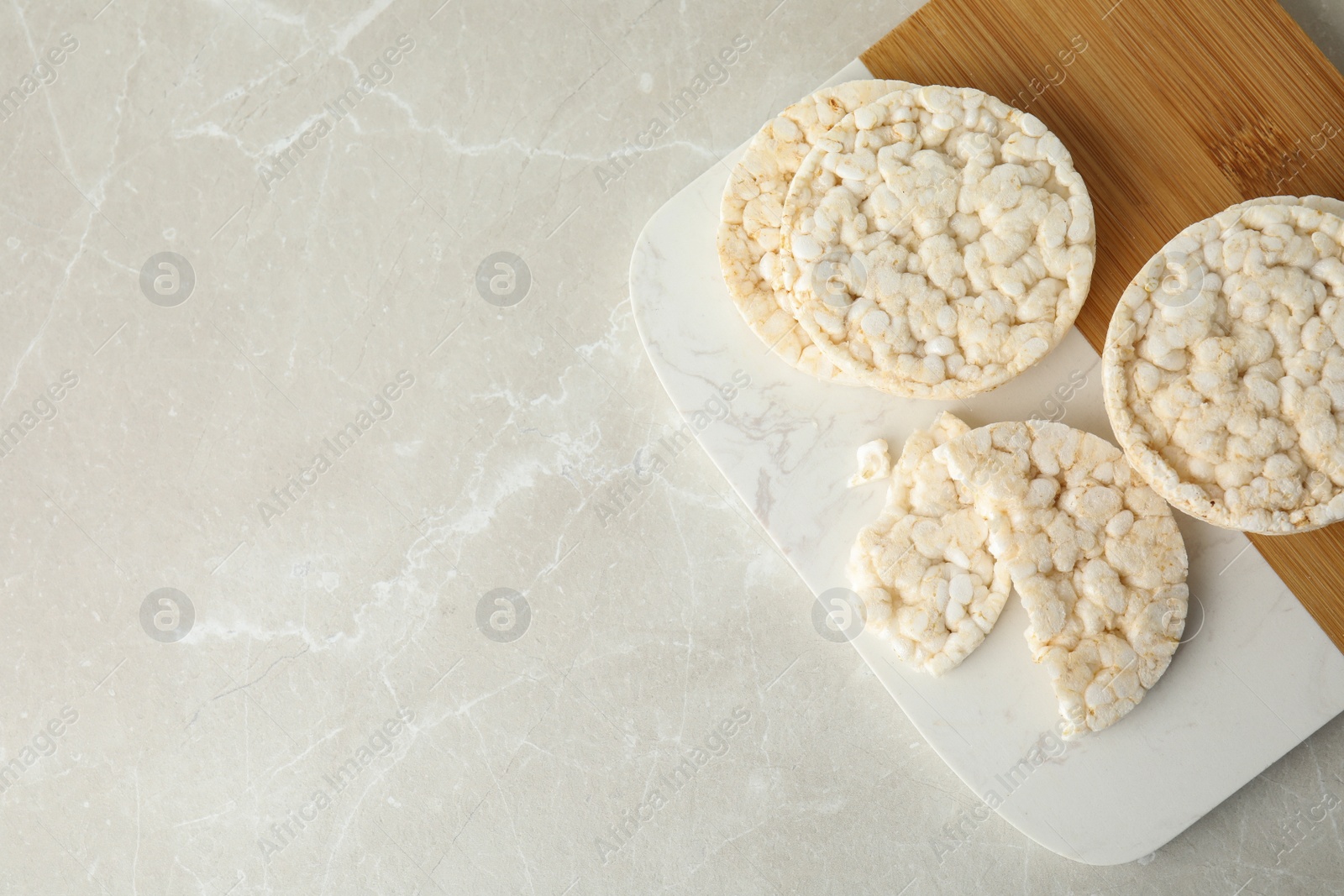 Photo of Puffed rice cakes on grey marble table, top view. Space for text