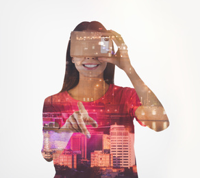 Double exposure of woman using virtual reality headset and cityscape. Modern technology