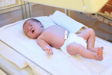 Newborn child under ultraviolet lamps in hospital