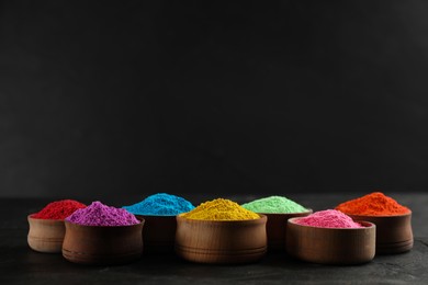 Colorful powder dyes on black background, space for text. Holi festival