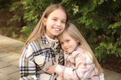 Cute little sisters spending time together outdoors