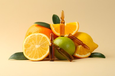 Photo of Skincare ampoules with vitamin C, different citrus fruits and leaves on beige background