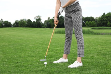 Photo of Woman playing golf on green course. Sport and leisure