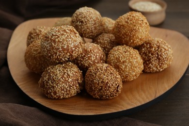 Photo of Many delicious sesame balls on wooden table, closeup